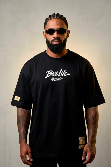 Modelo vestindo a Camiseta Oversized Apparel Brush Boss Life preta - frente com lettering em pincelada