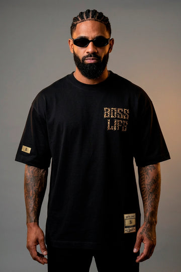 Modelo vestindo a Camiseta Oversized Leopard Urban Boss Life preta - frente com lettering em textura de onça
